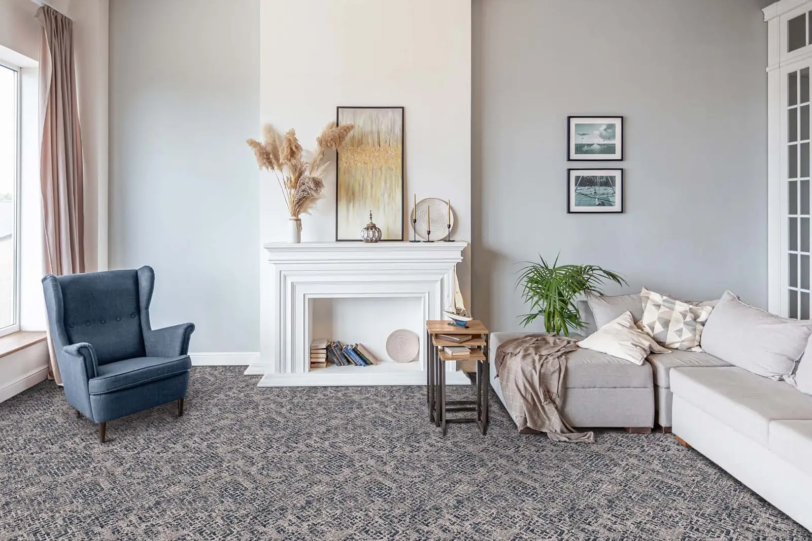 A bright living room with a soft patterned carpet, a blue wing chair and a pale sofa