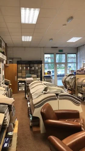 The shop interior with rolls of carpet and somewhere to sit
