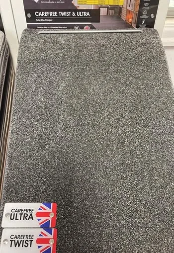 A close view of a grey twist pile carpet sample on a display stand