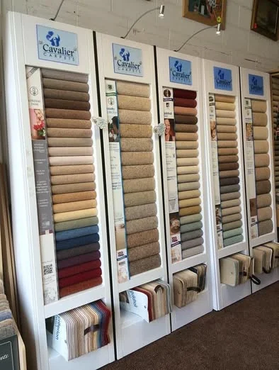 Rows of white carpet sample stands filled with colour swatches