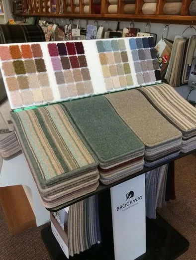 A carpet sample book with green, brown and cream swatches