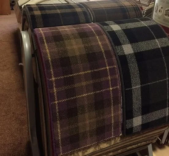 A large tartan carpet sample draped over a display stand